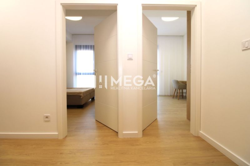 Open door in a 3-room apartment with a wooden decor floor.