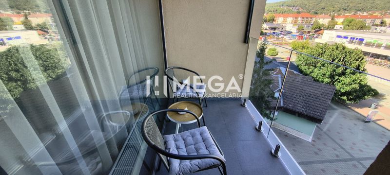 The balcony of a 3-room apartment in Humenné with outdoor seating and a view of the city.