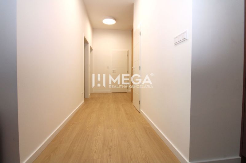 A hallway with light walls and a wooden decor floor in a 3-room apartment.