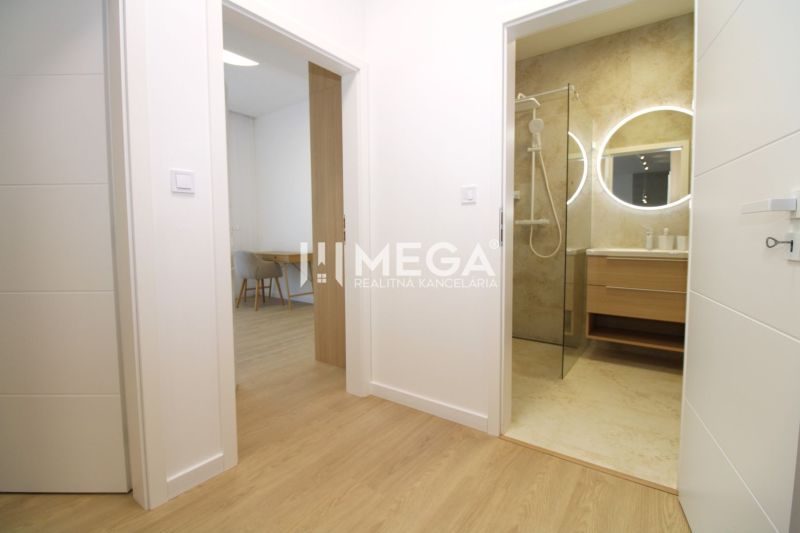 A hallway in a 3-room apartment with a visible bathroom and a floor with a wood decor.