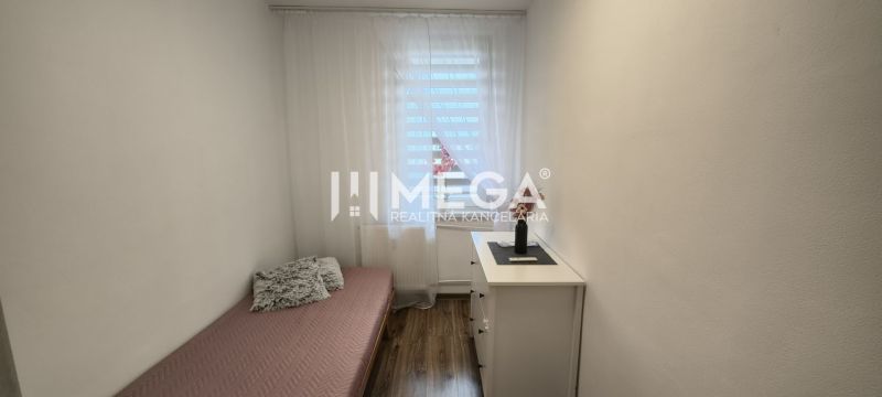 A simple interior of a 3-room apartment with a bed and a floor with a wooden decor.