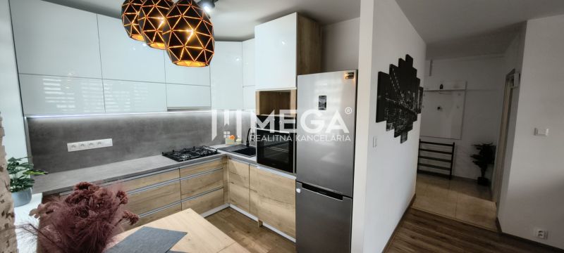 A kitchen in a 3-room apartment with appliances, a wooden decor floor, pendant lights.