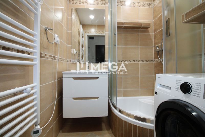 Bathroom in a 3-room apartment with a shower and a washing machine, tiles with a natural decor.