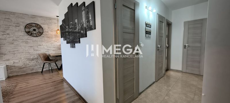 Interior of a 3-room apartment with a stone-clad wall and a floor with a wooden decor.