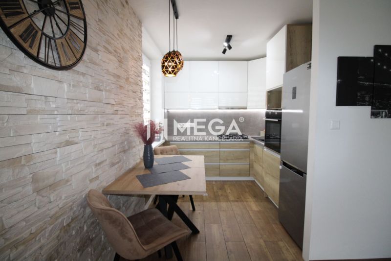 A kitchen in a 3-room apartment with a wooden decor floor and stone cladding.