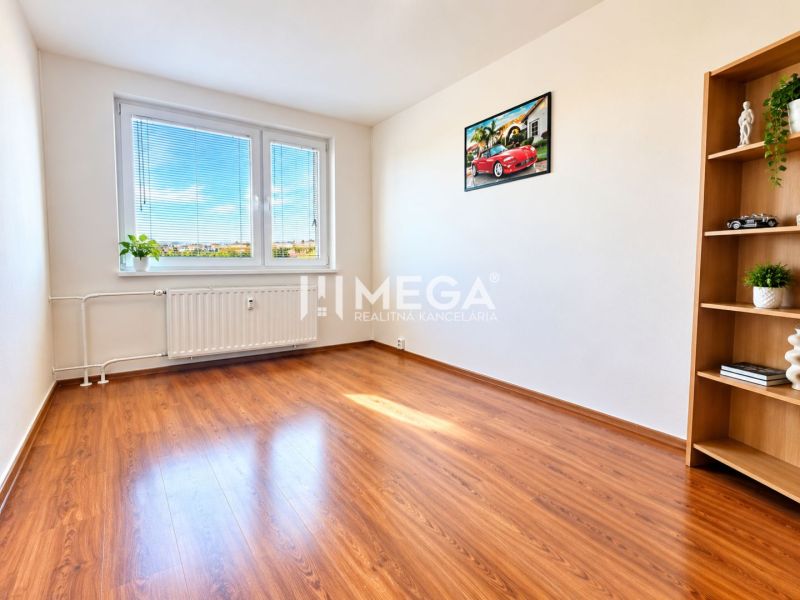 A room in a 4-room apartment with a wooden decor floor and light-colored walls.