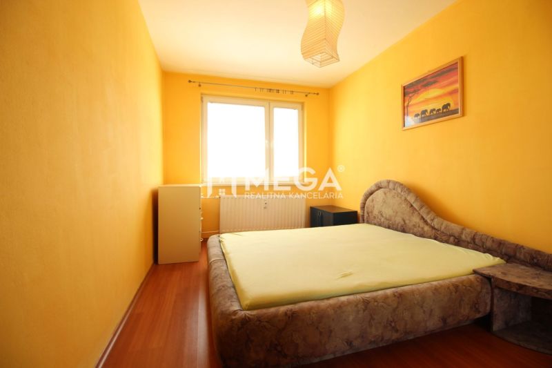 A bright bedroom with yellow walls and a wood-patterned floor in a 4-room apartment.