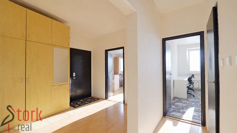 The entrance hall of a 3-room apartment with a large wardrobe and a floor with a wooden decor.