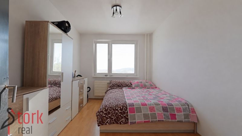 Bedroom in a 3-room apartment with a wardrobe and a wooden decor floor.