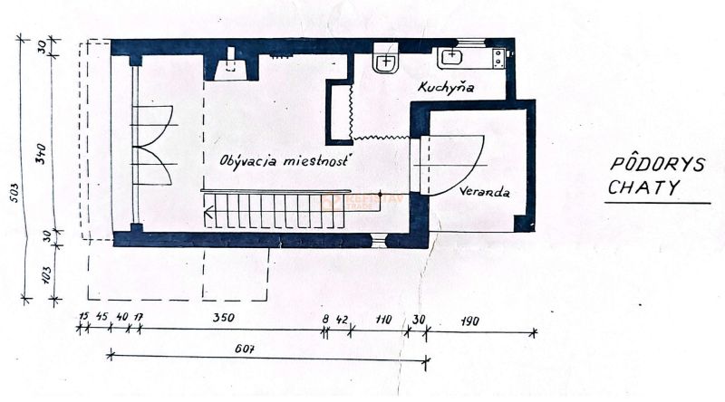 Floor plan of a cottage with an entrance veranda, living room, and kitchen. Gardens.