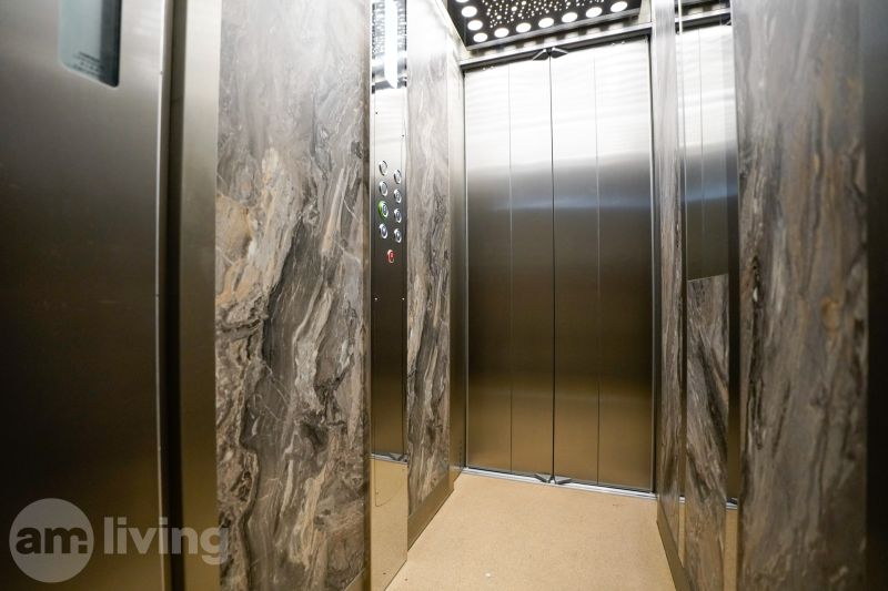 The interior of the elevator with marble walls and mirrors in a studio apartment.