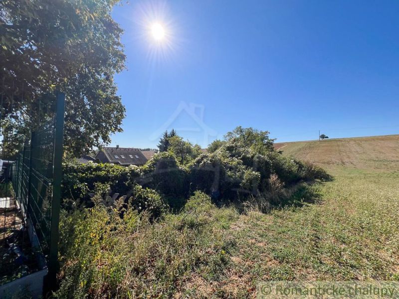 A sunny day in the gardens of Pastuchov with a view of the village and fields.