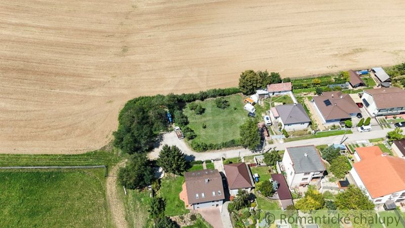 Aerial view of gardens in Pastuchov, surrounded by houses and fields.