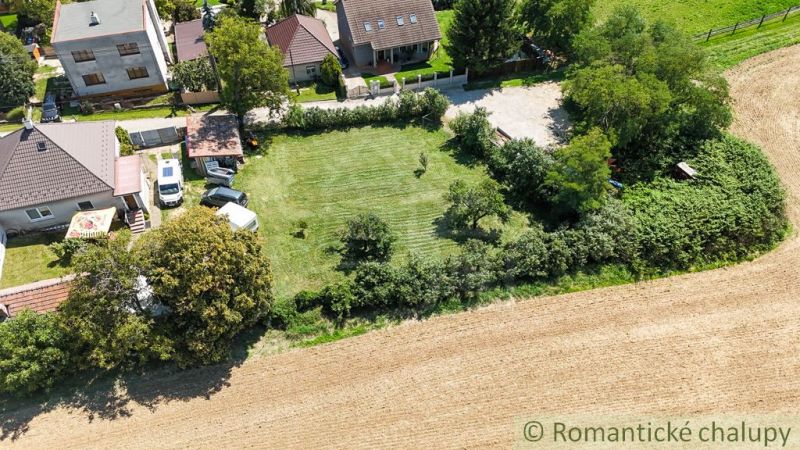 Houses with gardens in Pastuchov surrounded by fields and greenery.