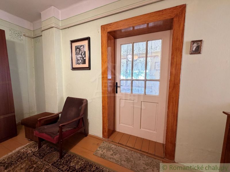A room in a family house with an armchair, carpet, and glass doors.