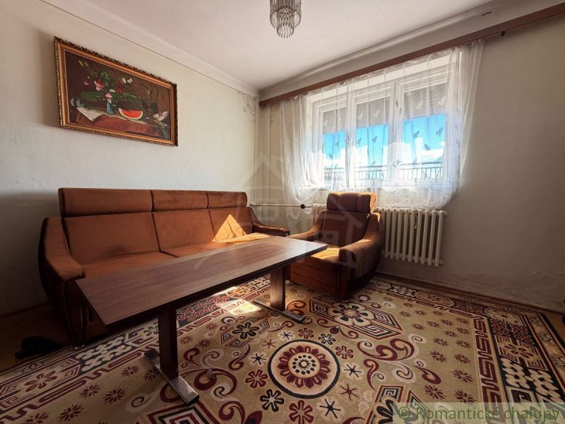 Living room in a family house with a brown sofa and curtains.
