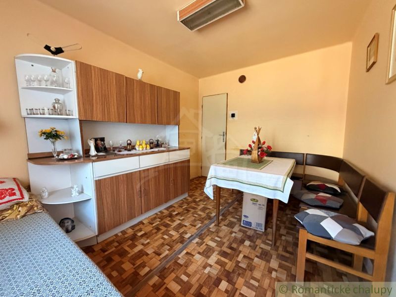 Interior of a family house with a dining table, wooden floor decor, and a classic cabinet.