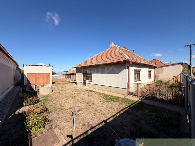 A family house in Hurbanovo with a yard, lawn, and an annex in the background.
