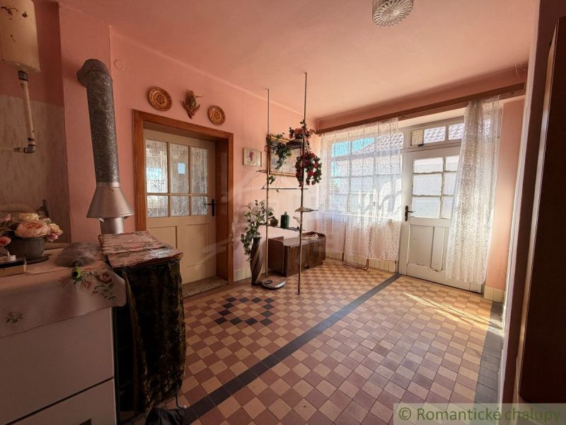 Interior of a family house with pink walls, tiled floor, and double doors.