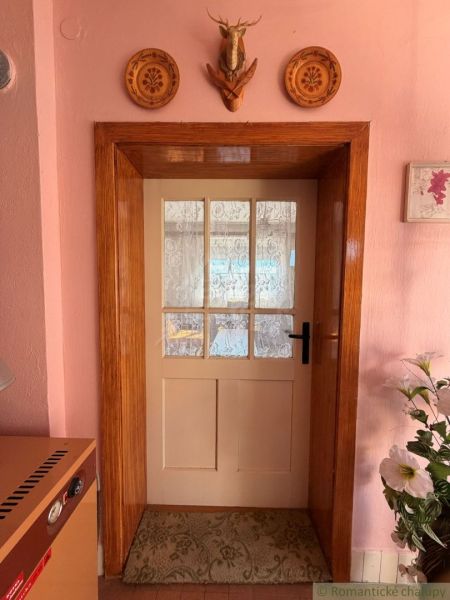 Interior of a family house with doors, embroidered curtains, and rustic decor.