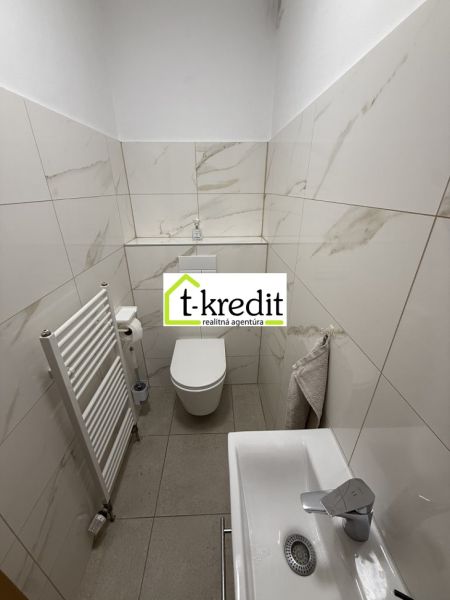 Bathroom in a family house with white tiles and a sink.