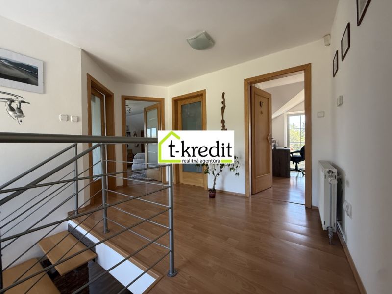 A hallway with a staircase and a wooden decor floor in a family house.