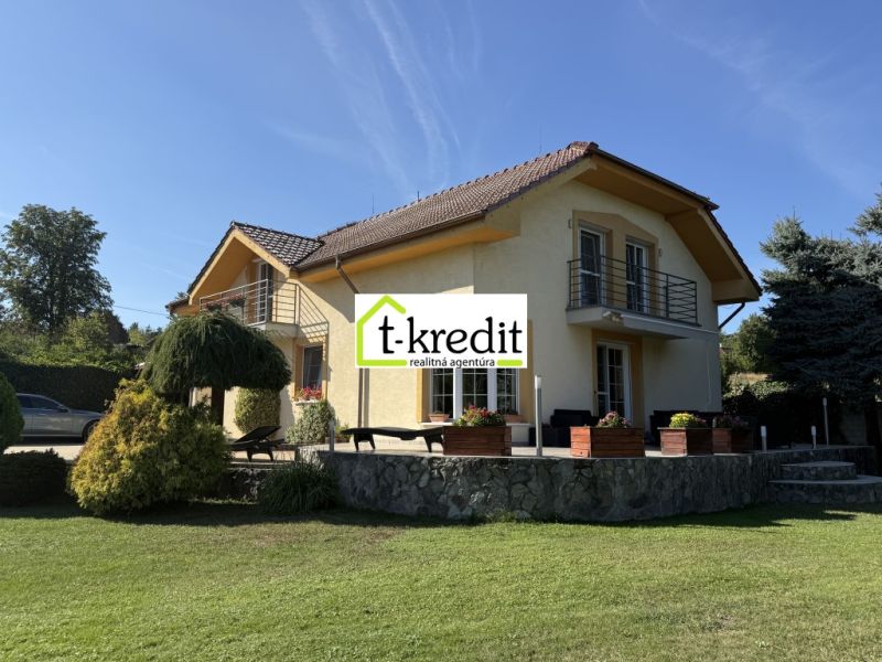 A family house in Zlaté Moravce, surrounded by greenery, with a stone terrace and a balcony.