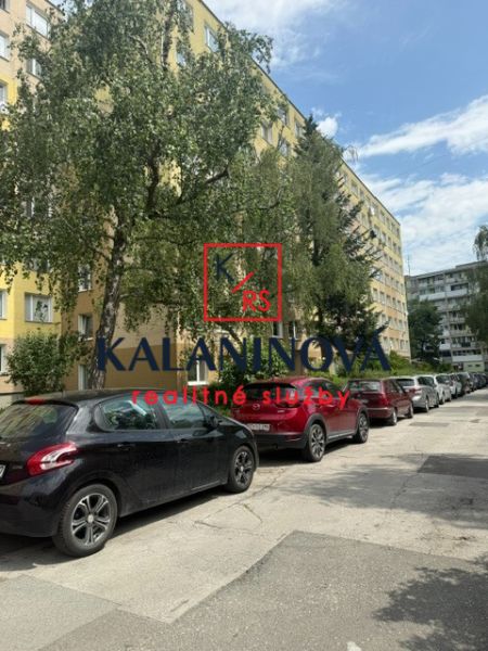 A view of Obrody Street in Košice - Západ with parked cars near a 4-room apartment.