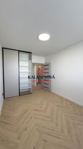 A room in a 4-room apartment with a wood-decor floor and a built-in wardrobe.