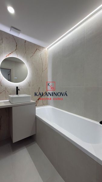 A bathroom with a rectangular bathtub and a round mirror in a 4-room apartment.