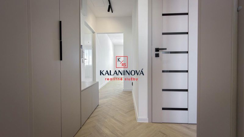 A hallway in a 4-room apartment with a floor and white doors.