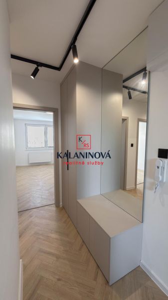 A hallway in a 4-room apartment with integrated storage space and a floor with a wooden decor.