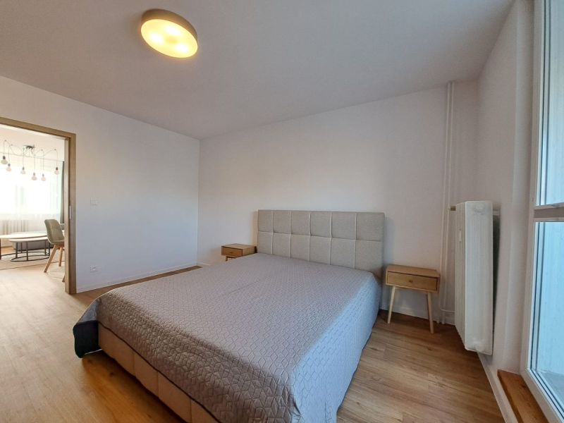 Bedroom with a bed and nightstands, wooden decor flooring in a two-room apartment.