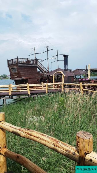 A wooden boat as an attraction at the cottage on the Senec Lakes, behind a wooden fence.