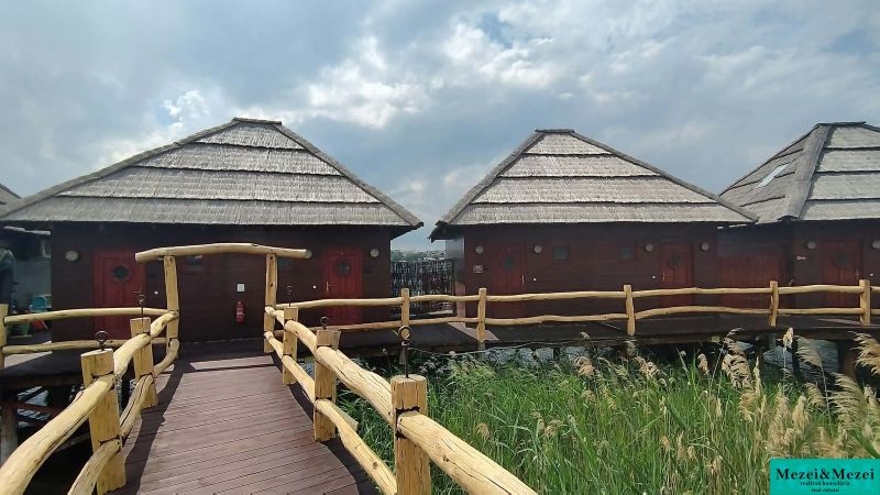 Wooden cabins above the water surface with thatched roofs at Senec Lakes.
