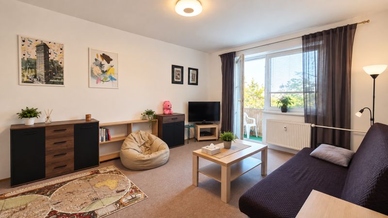 Living room in a 3-room apartment with comfortable seating and access to a balcony.