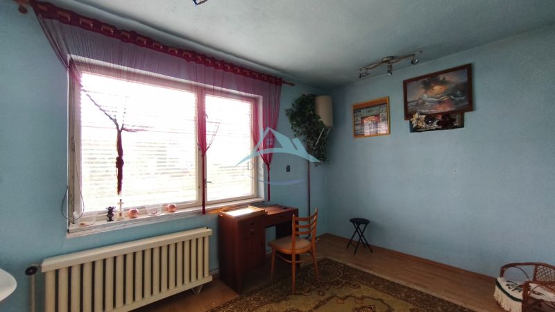 Blue room with a window, table, and chair in a family house.