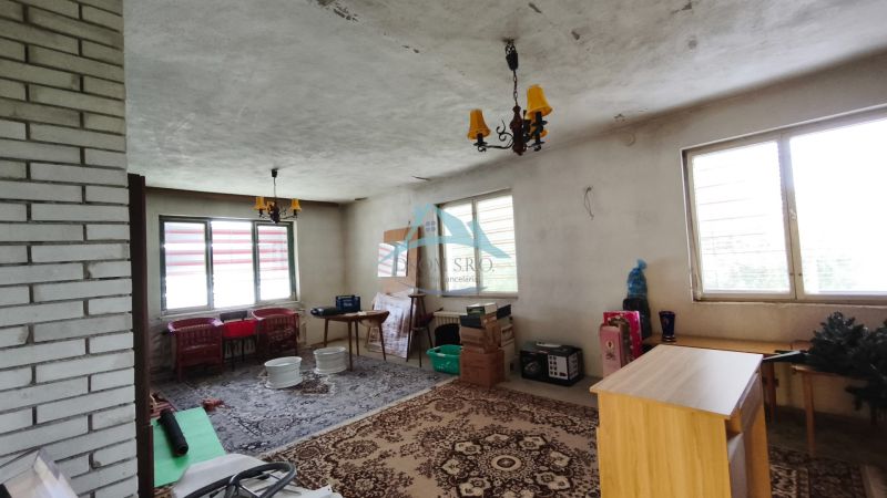 Interior of a family house with plastic windows, a brick wall, and a decorative carpet.