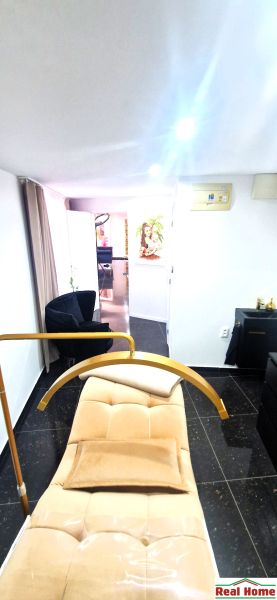 Commercial space with a cosmetic bed, black chairs, and white walls.