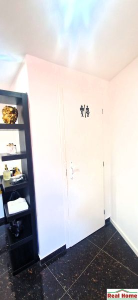 Interior of commercial premises with a door to the toilet and a decorative shelf.