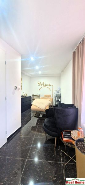 Interior commercial spaces with a sofa set, mirror, and gold accessories.