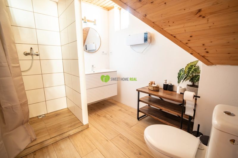 Bathroom with wood-patterned flooring, shower, and sink. Hotels and guesthouses.