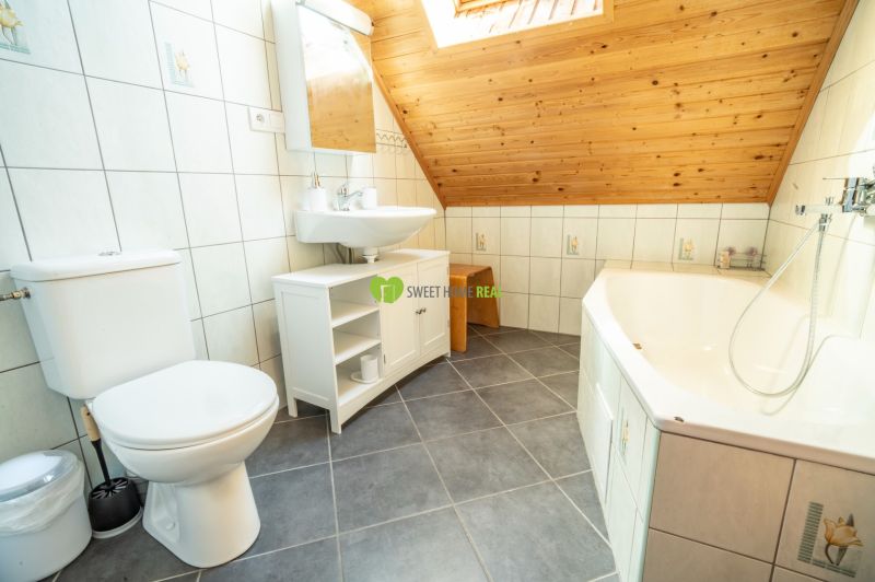 Bathroom with a bathtub, sink, and tiles in hotels and guesthouses.