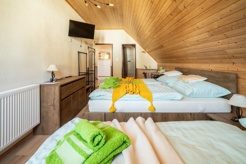 Room in a hotel and guesthouse with wooden decor flooring and comfortable beds.