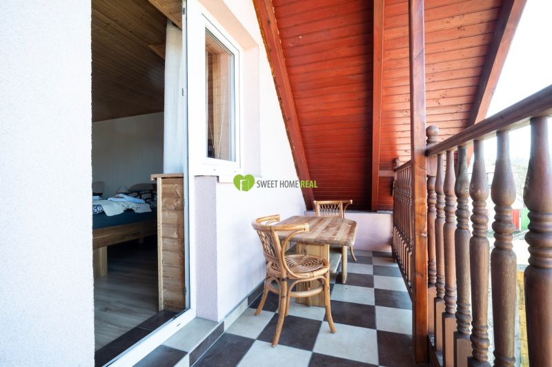 A balcony with a wooden table and a view from hotels and guesthouses in Liptovský Michal.