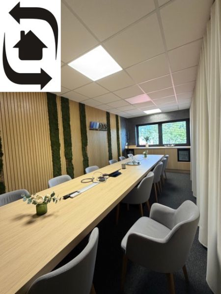 Conference room in a building with a wood-patterned floor and a long table.