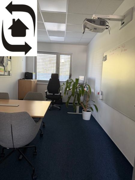 The interior of an office with a whiteboard, conference table, and projector on the wall of the building.