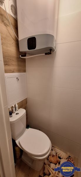 A toilet with a wooden decor floor in a 3-room apartment.