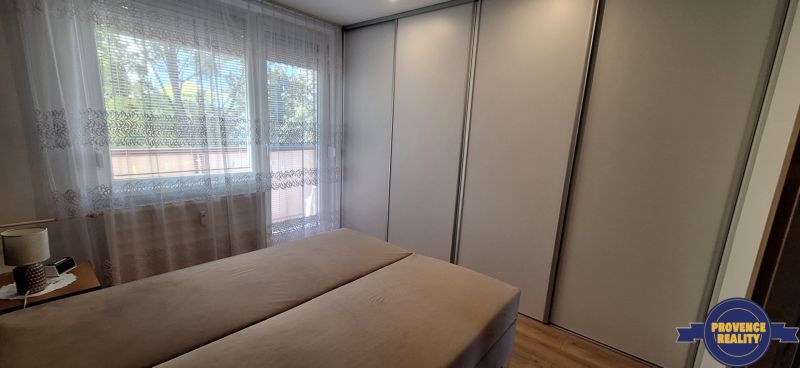 Bedroom in a 3-room apartment with a large wardrobe and a window with curtains.
