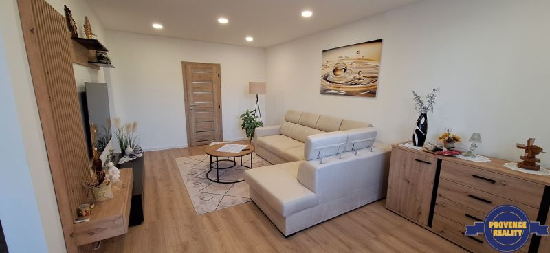 Living room in a three-room apartment with a wooden decor floor and a comfortable sofa.